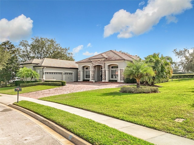 mediterranean / spanish house featuring a garage and a front yard