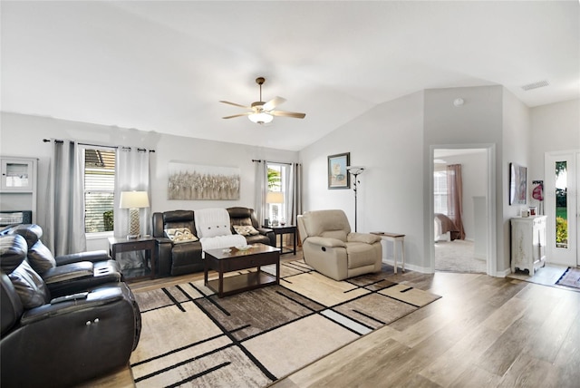 living room with ceiling fan, lofted ceiling, and light hardwood / wood-style flooring