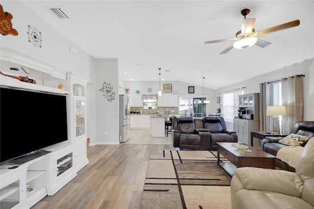 living room with ceiling fan, light hardwood / wood-style floors, and lofted ceiling