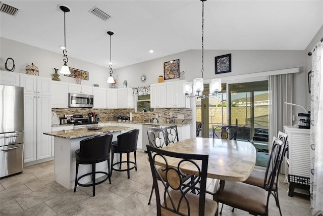 dining space featuring vaulted ceiling, a notable chandelier, and sink