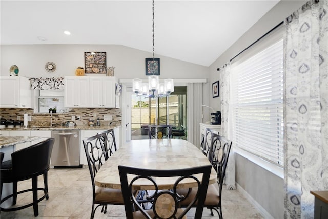 tiled dining area featuring a chandelier and vaulted ceiling