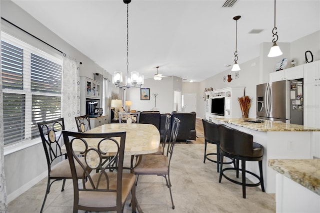 tiled dining space with ceiling fan with notable chandelier