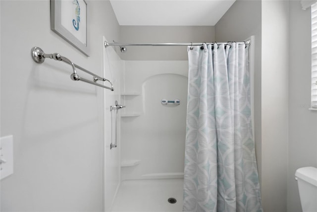 bathroom featuring curtained shower and toilet