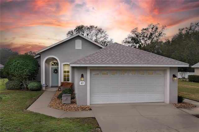 view of front of property with a lawn and a garage