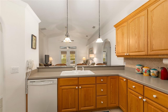 kitchen featuring dishwasher, sink, backsplash, vaulted ceiling, and decorative light fixtures