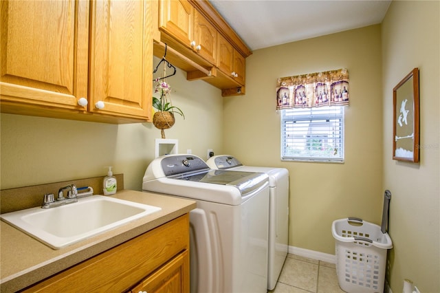 clothes washing area featuring washer and dryer, light tile patterned flooring, cabinets, and sink