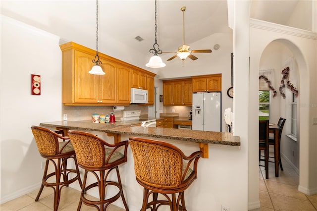 kitchen with a breakfast bar, white appliances, decorative backsplash, decorative light fixtures, and kitchen peninsula