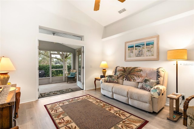 living room featuring ceiling fan, light hardwood / wood-style flooring, and vaulted ceiling