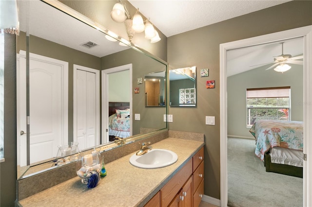 bathroom featuring ceiling fan, vanity, and a textured ceiling