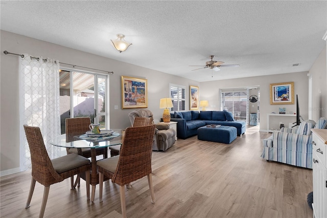 dining room featuring ceiling fan, a textured ceiling, and light wood-type flooring