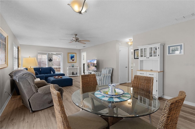 dining area featuring ceiling fan, a textured ceiling, and light hardwood / wood-style floors