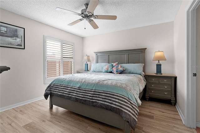 bedroom featuring ceiling fan, light hardwood / wood-style floors, and a textured ceiling