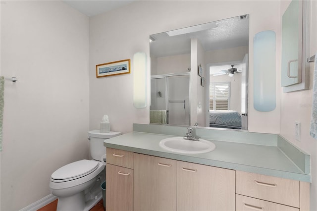 bathroom featuring ceiling fan, vanity, toilet, and a shower with door