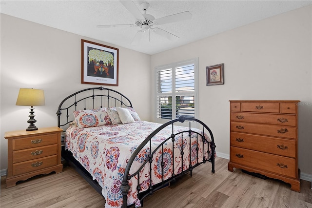 bedroom with ceiling fan, a textured ceiling, and light wood-type flooring