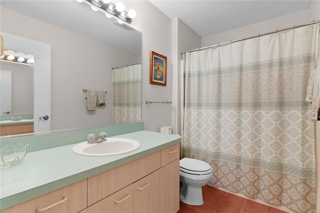 bathroom with tile patterned flooring, vanity, toilet, and a textured ceiling