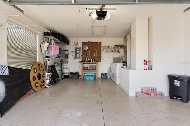 garage featuring washing machine and clothes dryer, a garage door opener, and electric panel