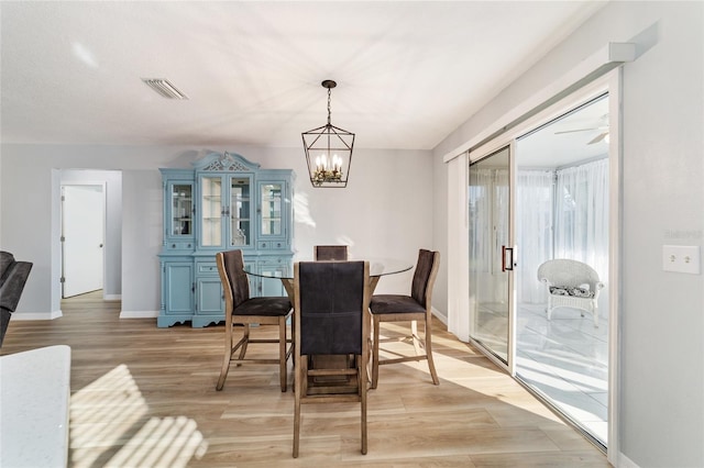 dining area featuring light wood-type flooring and an inviting chandelier