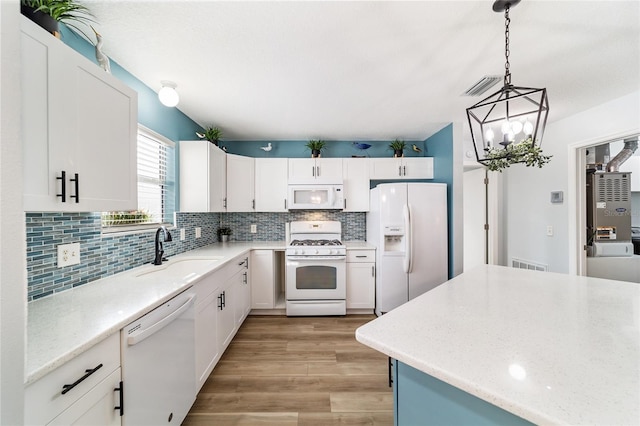 kitchen with pendant lighting, white cabinets, white appliances, and sink