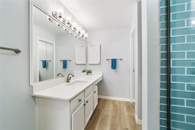 bathroom featuring vanity, wood-type flooring, and a textured ceiling