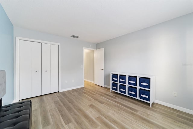 unfurnished bedroom with light wood-type flooring and a closet