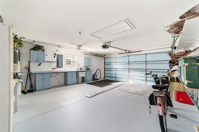 garage featuring electric panel, ceiling fan, a garage door opener, and gas water heater