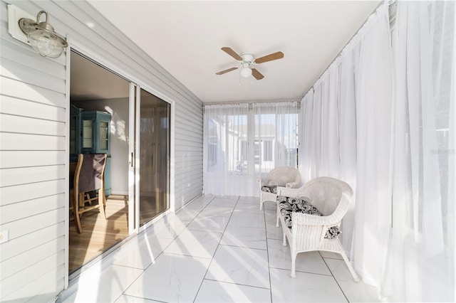 sunroom / solarium featuring ceiling fan