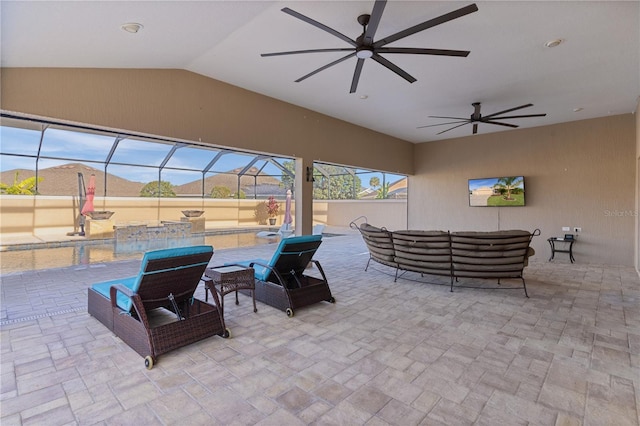 view of patio / terrace featuring a mountain view, an outdoor hangout area, glass enclosure, and ceiling fan