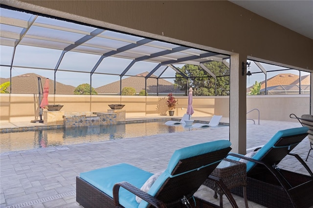 view of patio / terrace featuring a mountain view, pool water feature, glass enclosure, and a pool with hot tub