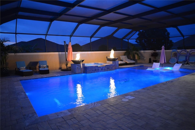 view of pool with an in ground hot tub, a patio, pool water feature, and a lanai