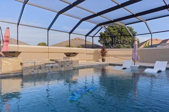 view of swimming pool featuring pool water feature and glass enclosure