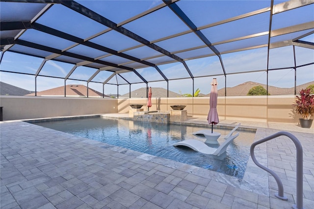 view of pool featuring glass enclosure, a patio area, and a mountain view