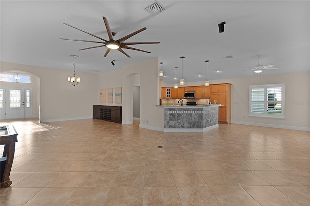 unfurnished living room with light tile patterned floors and ceiling fan with notable chandelier