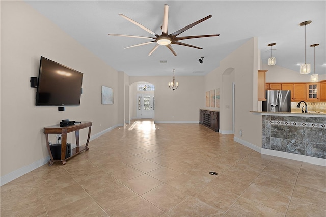 tiled living room with ceiling fan with notable chandelier and sink