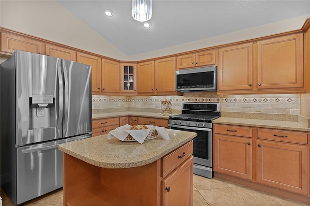 kitchen with tasteful backsplash, stainless steel appliances, vaulted ceiling, a kitchen island, and hanging light fixtures