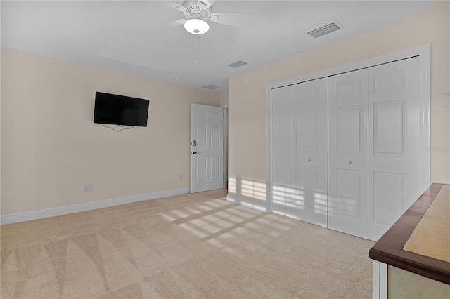 unfurnished bedroom with ceiling fan, a closet, and light colored carpet