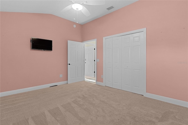 unfurnished bedroom with light carpet, a closet, ceiling fan, and lofted ceiling