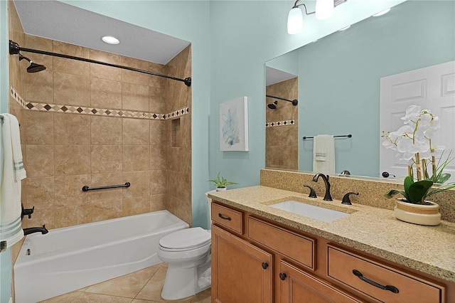 full bathroom with tile patterned flooring, vanity, tiled shower / bath combo, and toilet