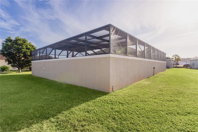 view of home's exterior with a yard and glass enclosure