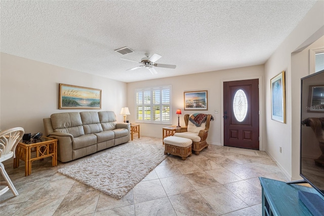 living room with ceiling fan and a textured ceiling