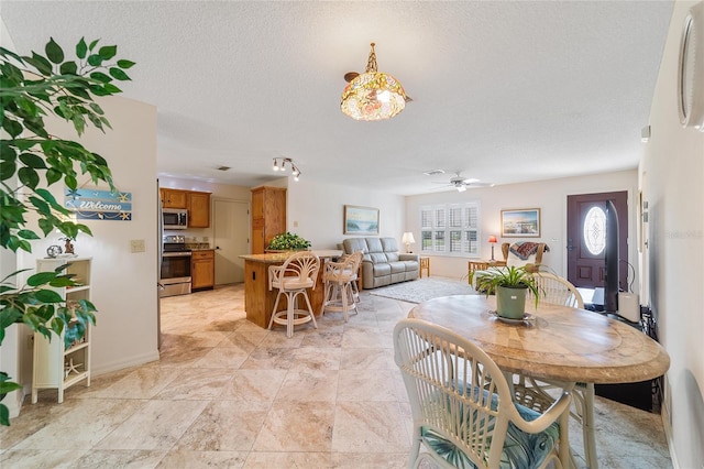 dining room with ceiling fan and a textured ceiling