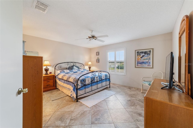 bedroom featuring ceiling fan and a textured ceiling