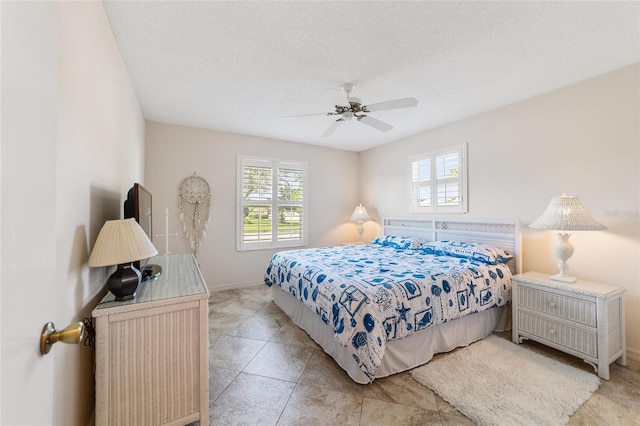 bedroom featuring multiple windows, a textured ceiling, and ceiling fan