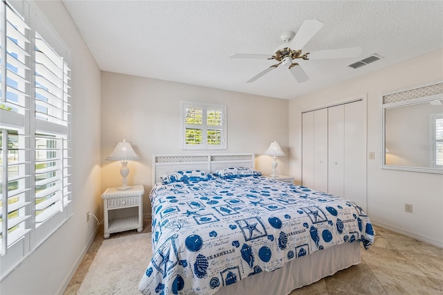 bedroom with ceiling fan, a textured ceiling, and a closet