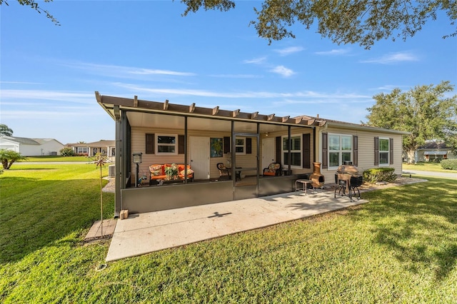 rear view of property with a yard and a patio