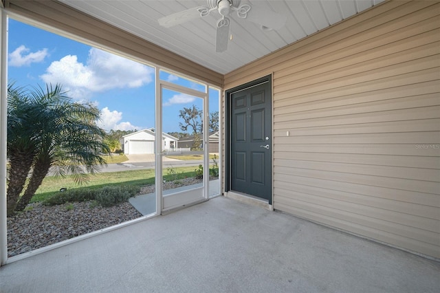 unfurnished sunroom with ceiling fan