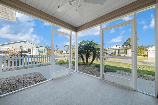 unfurnished sunroom with ceiling fan