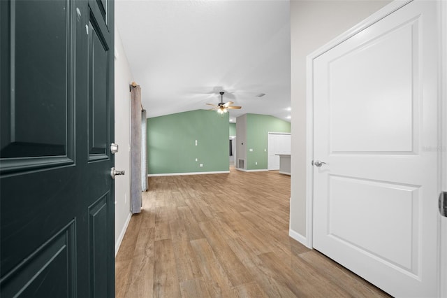 interior space featuring ceiling fan, light hardwood / wood-style floors, and lofted ceiling