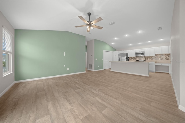 unfurnished living room featuring ceiling fan, light wood-type flooring, and lofted ceiling