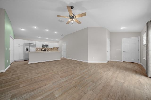 unfurnished living room featuring ceiling fan, lofted ceiling, and light hardwood / wood-style flooring