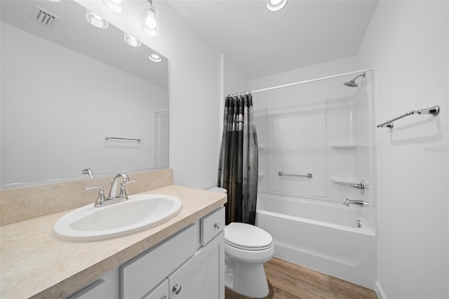 full bathroom featuring hardwood / wood-style floors, vanity, toilet, and shower / tub combo with curtain